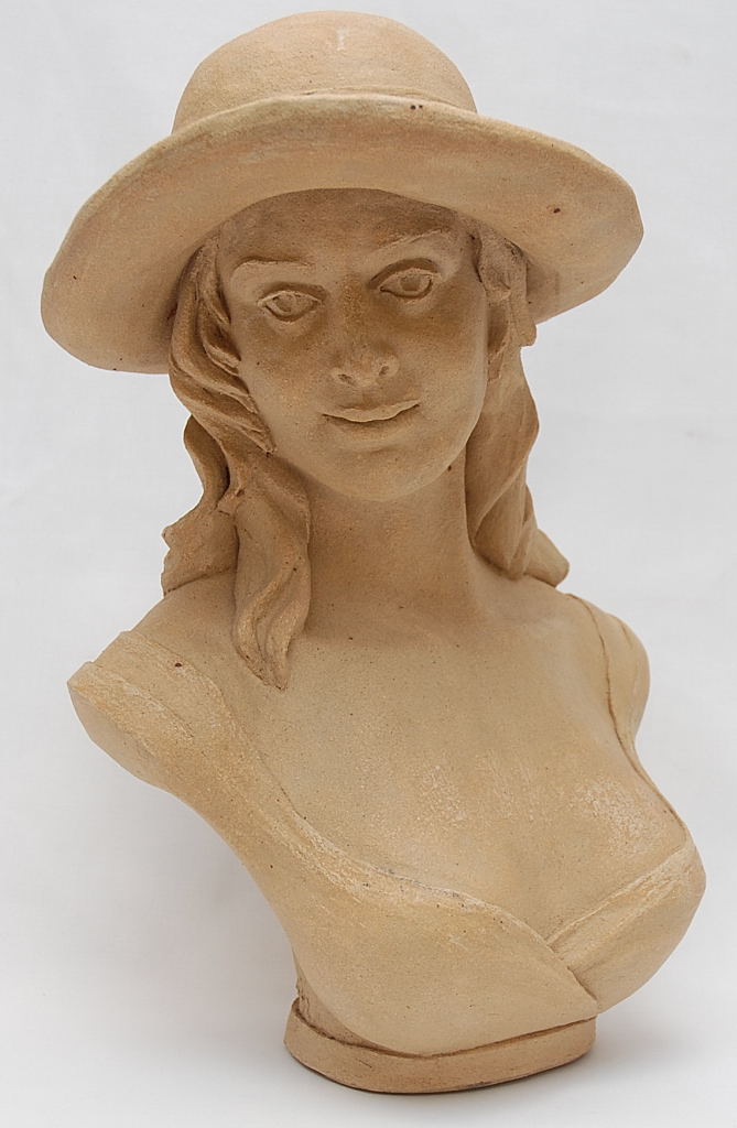 AN ART POTTERY SCULPTURE OF A WOMAN WITH WIDE BRIMMED HAT BEARING SIGNATURE W.M. CANN '92