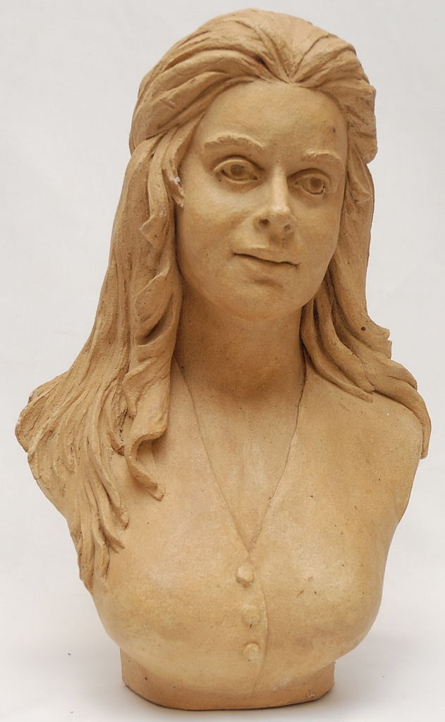 AN ART POTTERY SCULPTURE OF LONG HAIRED WOMAN WITH A BOW IN HER HAIR, BEARING SIGNATURE W.M. CANN '