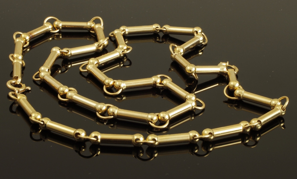 An 18ct gold fancy link chain, of cylindrical and hoop design, 65 cm (25 1/2 in) long, divides to