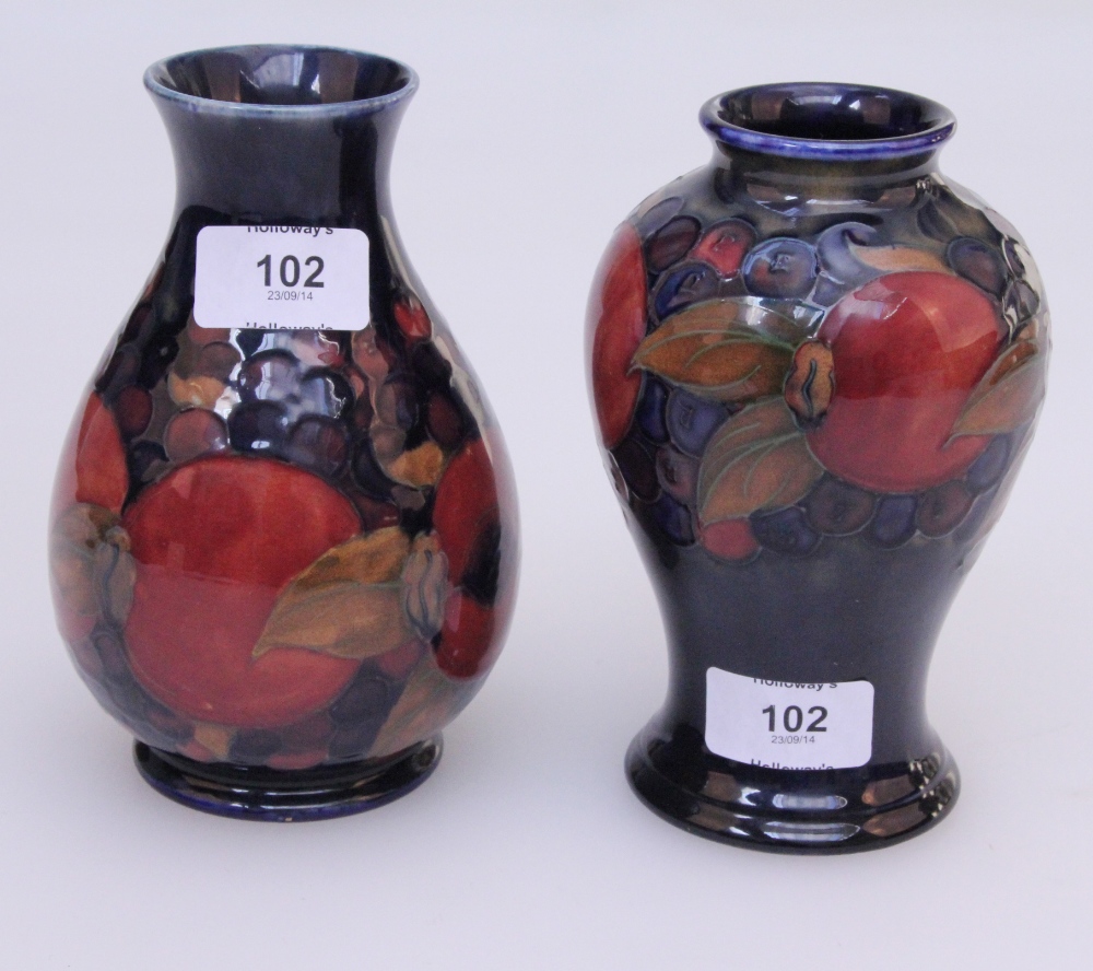 Two Moorcroft vases, a baluster vase of pomegranate design, tube lined and painted decoration on a