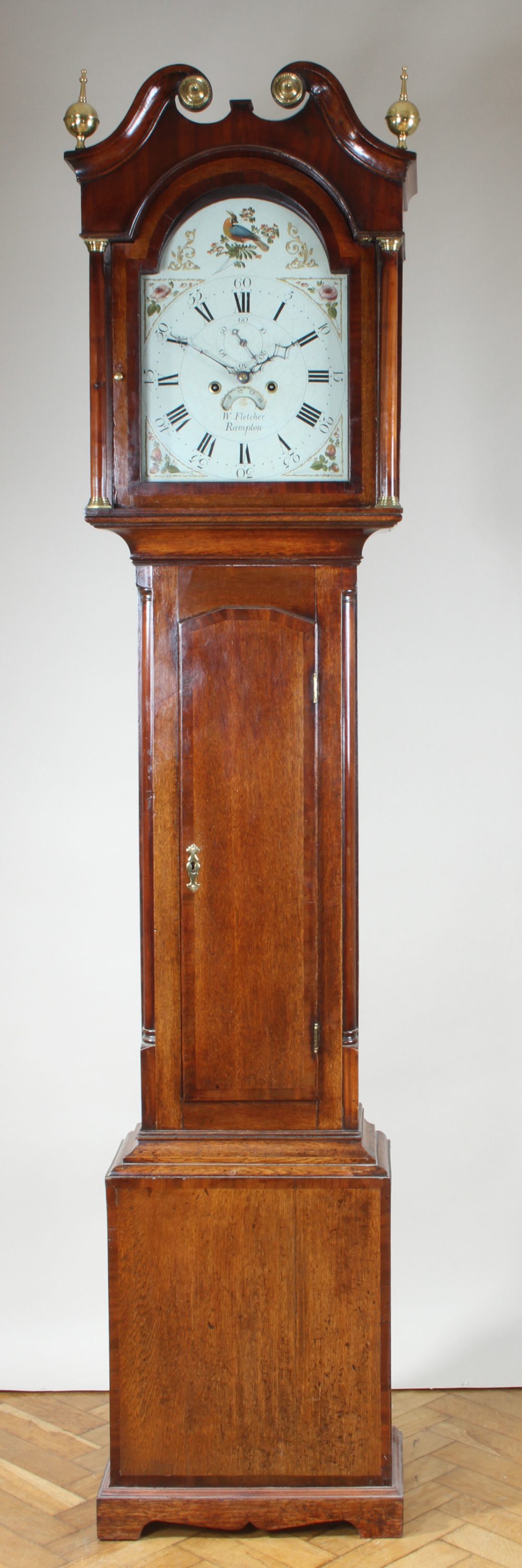 A George III oak cross banded eight day long case clock, by W Fletcher of Rampton, the painted dial