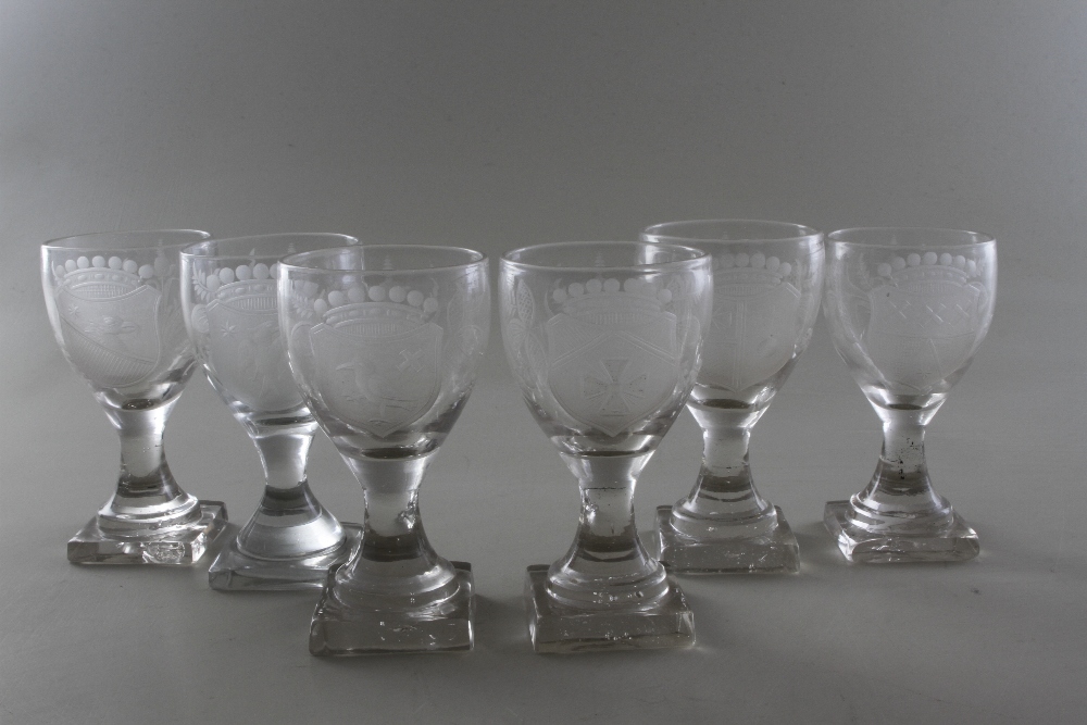 A set of six close-matched George III square-footed clear glass stemmed wines, with various