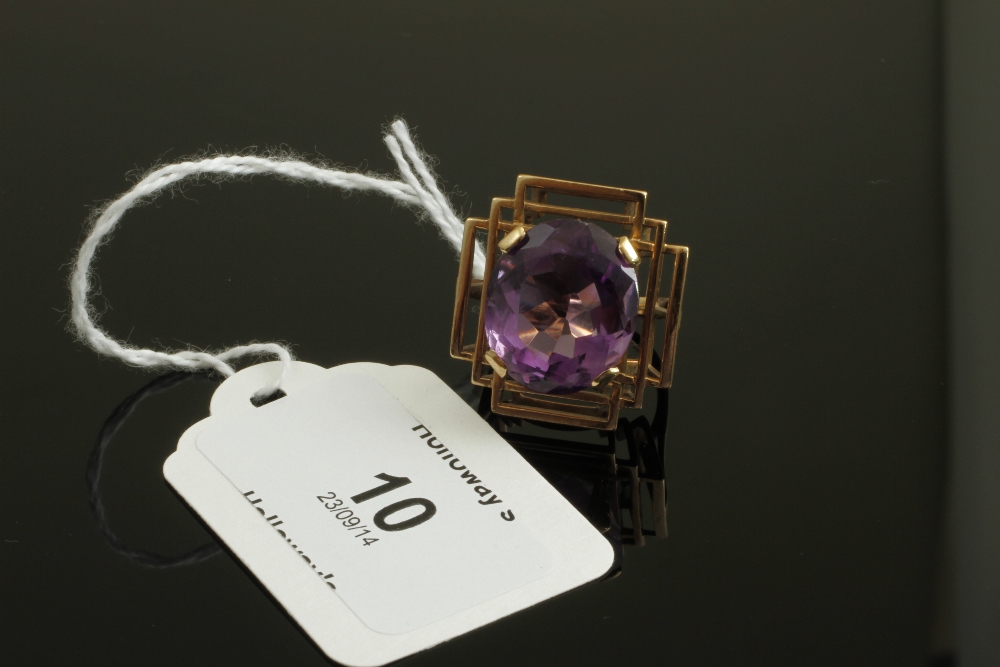 An amethyst dress ring, the large oval-cut amethyst claw set in open wire work graduated box mount