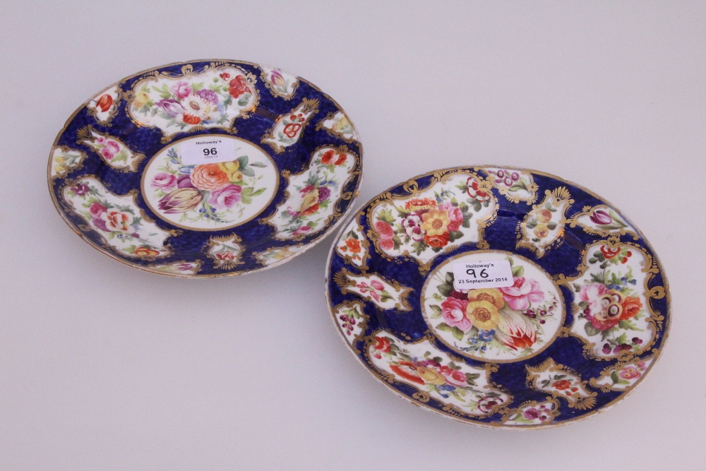 A pair of early 19th century English porcelain dessert plates, painted with a blue scale and floral