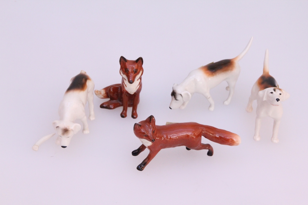 A Beswick pottery seated fox, together with a Beswick fox standing four square and three hounds