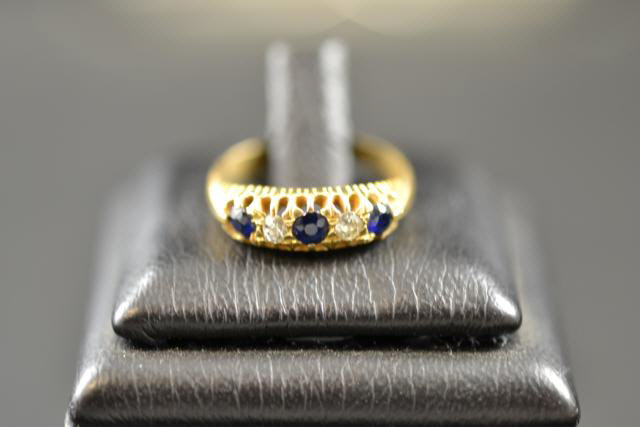 An 18ct gold ring set with three sapphires and two diamonds, size L 1/2 - approx gross weight 3.4g