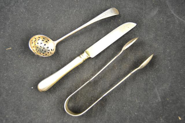 A Victorian silver sifter spoon, Exeter 1878, a pair of Victorian silver sugar tongs, London 1871,