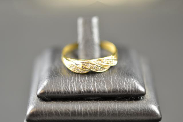 An 18ct gold ring with nine diamonds in a twist setting, size O - approx gross weight 2.2g