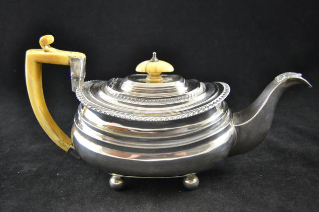 A late Georgian William Bateman silver teapot (London 1824), gadrooned decoration, four ball feet,