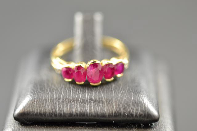 A yellow metal ring set with five rubies, size N - approx gross weight 2.2g