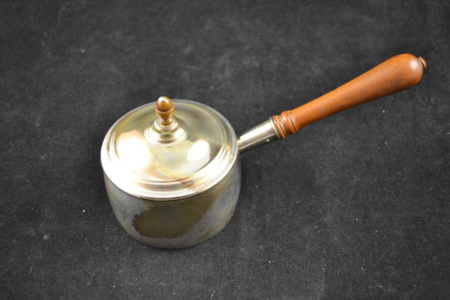 A continental white metal (probably silver) brandy warmer with turned fruitwood handle and turned