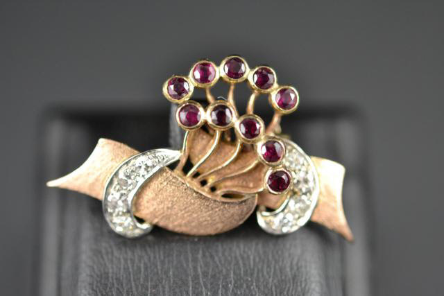 A yellow metal (tests as 9ct) floral spray brooch set with ten rubies and eight diamonds, W3.5cm -