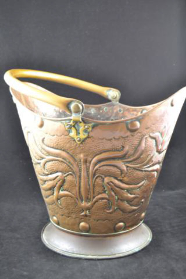 A Newlyn style embossed copper coal helmet, brass swing handle, stylized foliate decoration - W38cm,