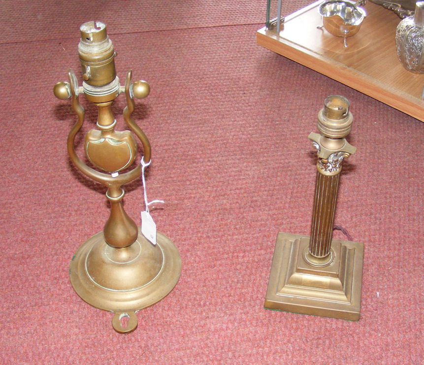 An early ship’s brass gimballed electric wall light and a brass Corinthian column table lamp.