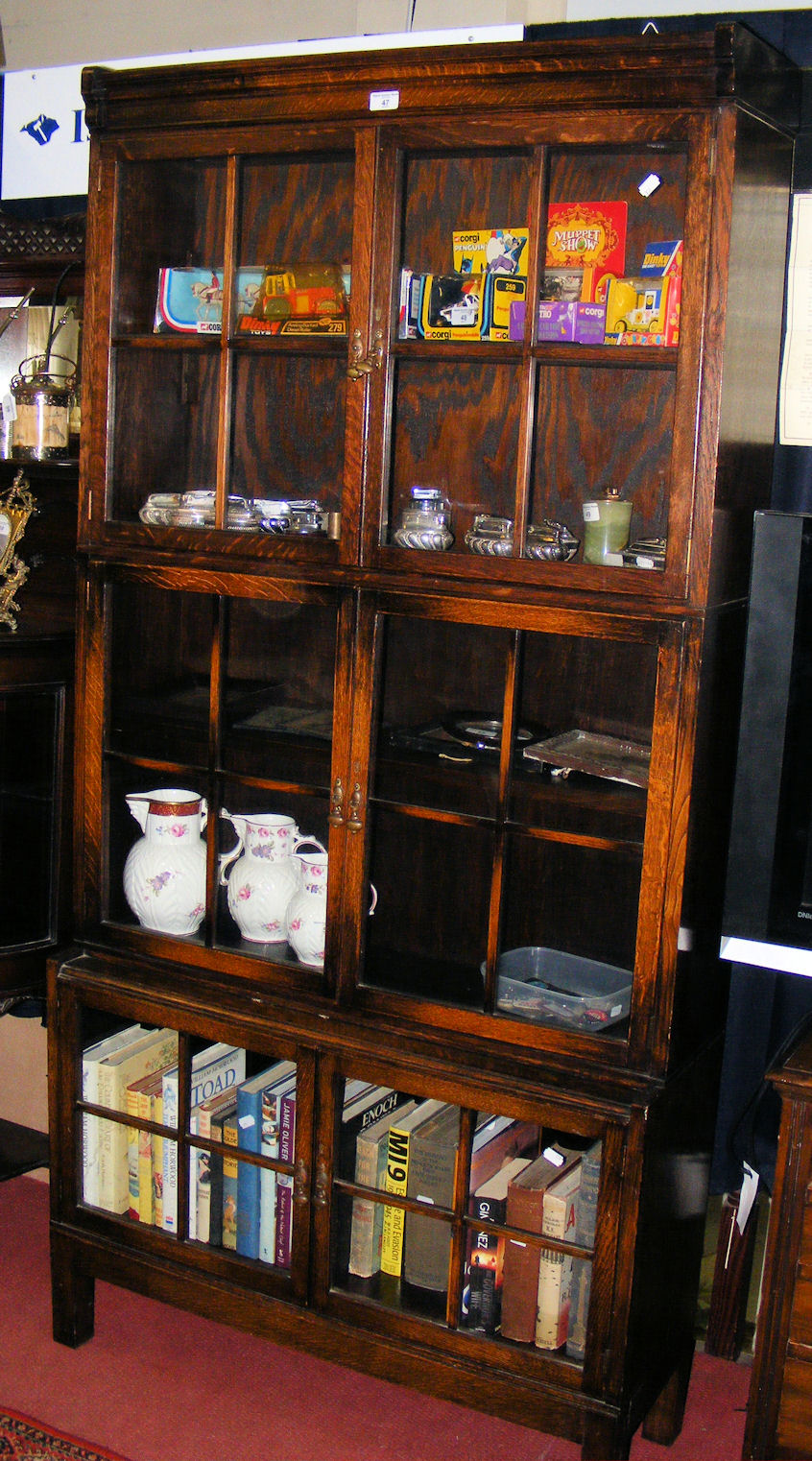 An oak three tier Globe Wernicke style bookcase enclosed by glazed and beaded doors.