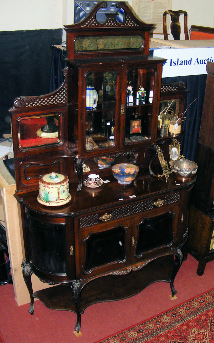 An Edwardian mahogany side cabinet with bevelled mirrored panels to the top, cupboards under