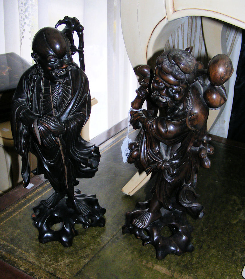 A pair of carved oriental hardwood figures.