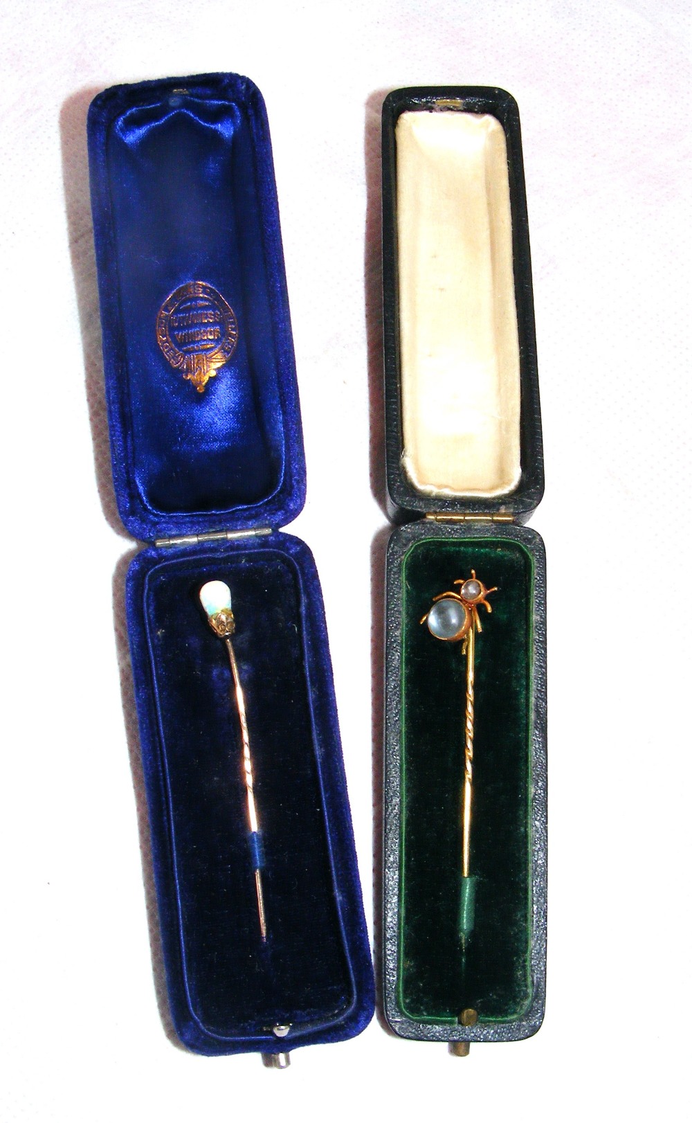 A 15ct gold stick pin with inset stones in original case & another example also cased.