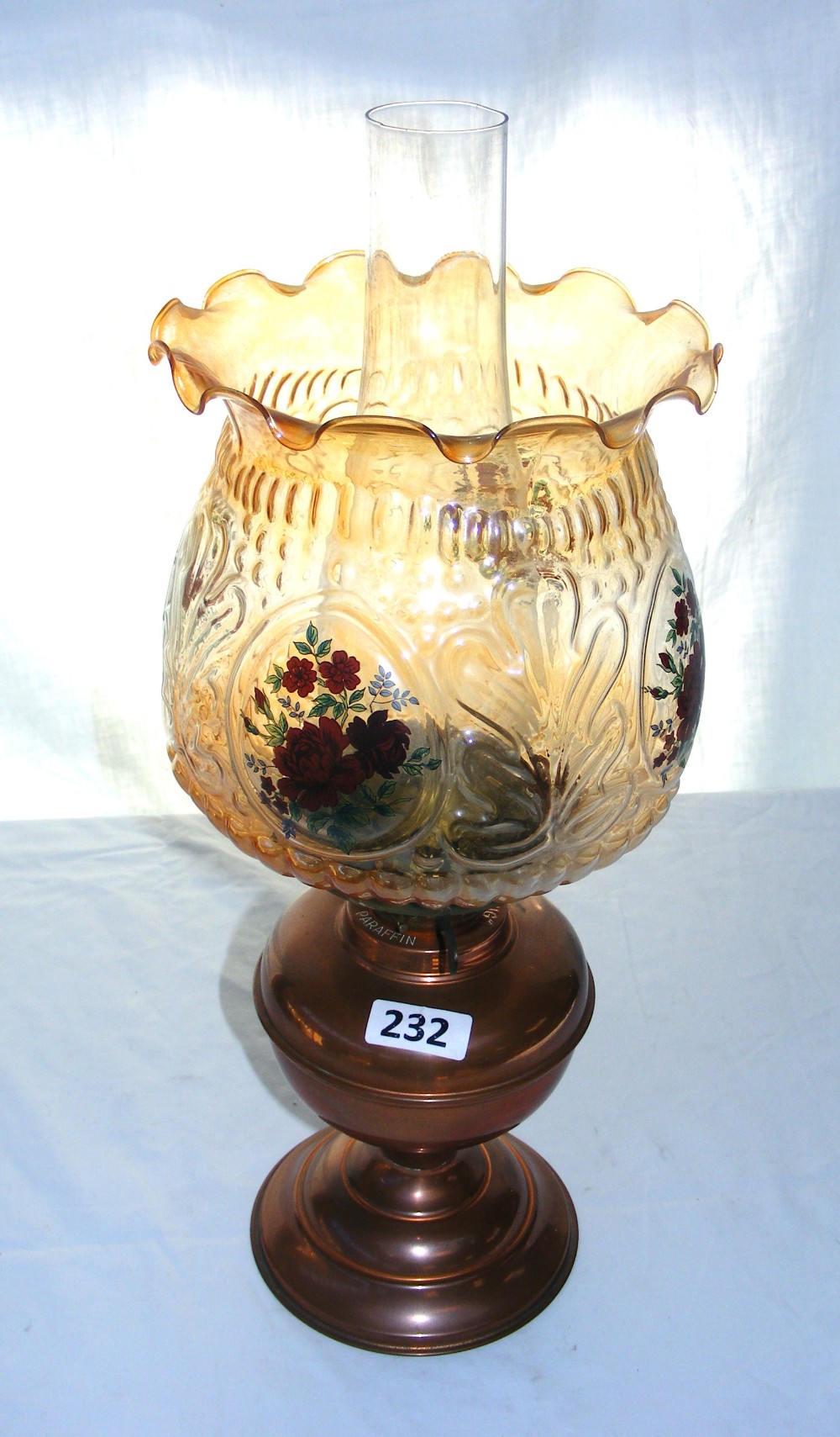 A copper parraffin oil lamp, chimney & shade decorated with flowers, measuring 46cm tall.