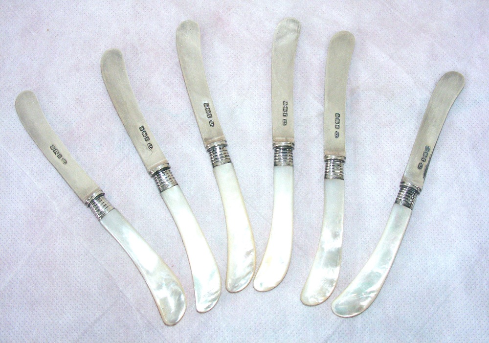 A set of six butter knives with mother of pearl handles & sterling silver blades & ferrules