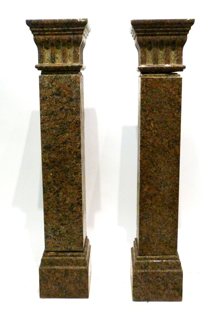 A Pair of Granite Torchere, in the form of capitals with square bases, 108 cms tall