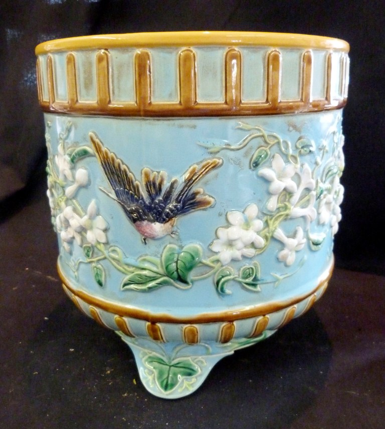 A George Jones Majolica Jardiniere, decorated in relief with birds amongst foliage upon a pale blue