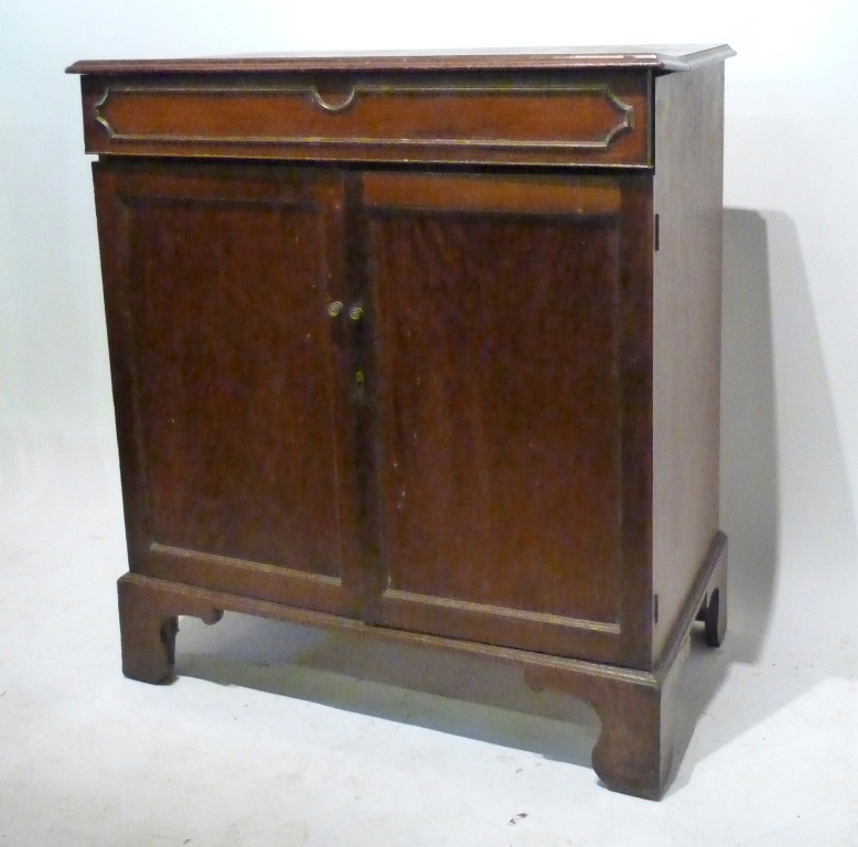 A George III Mahogany Side Cabinet, with a hinged top above two panelled doors raised upon bracket