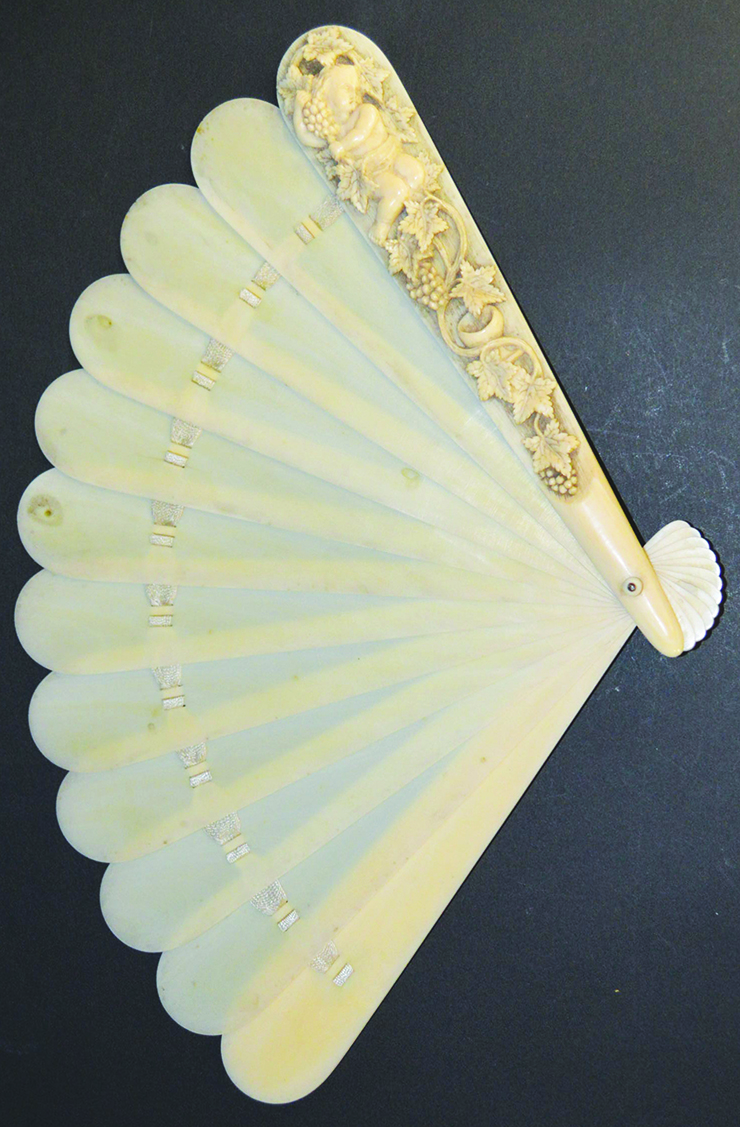 A GOOD EUROPEAN CARVED IVORY FAN, carved with a cupid and fruiting vines.