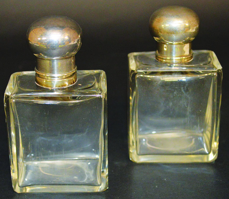 A PAIR OF .925 SILVER MOUNTED SCENT BOTTLES AND STOPPERS.