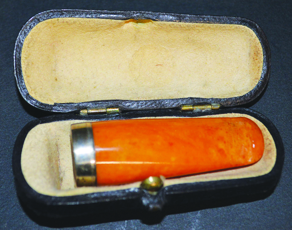 A SILVER TOP AMBER CIGARETTE HOLDER in a leather case.