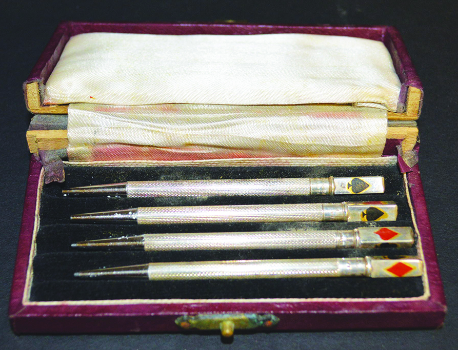 A SET OF FOUR STERLING SILVER AND ENAMEL PLAYING CARD PENCILS in a box.