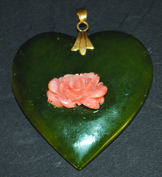 A JADE HEART SHAPED PENDANT with gold clasp and set with a coral rose.