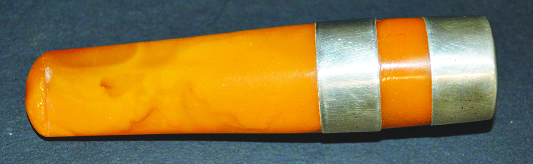 A SILVER TOP AMBER CIGARETTE HOLDER in a leather case.