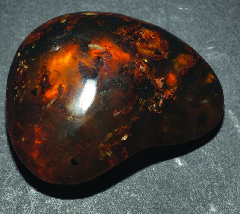 AN AMBER PEBBLE, of honey coloured tone with darker inclusions, 2.3in long.