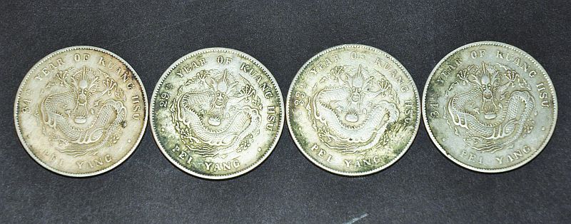 FOUR CHINESE SILVER-METAL COINS, weighing 107gm together, each 1.5in diameter. (4)