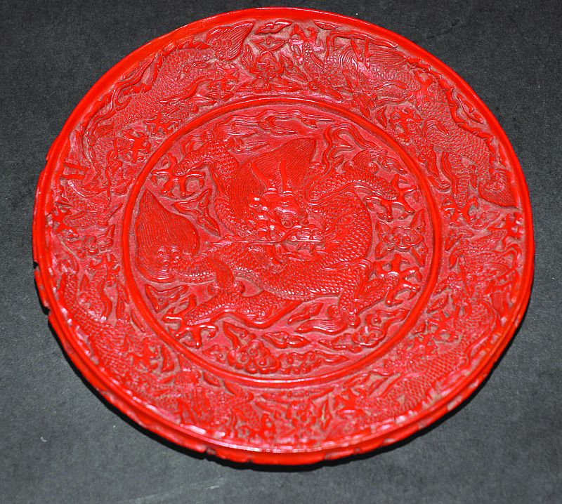 A CHINESE CINNABAR LACQUER DISH, the interior decorated to its centre with a sinuous dragon amidst