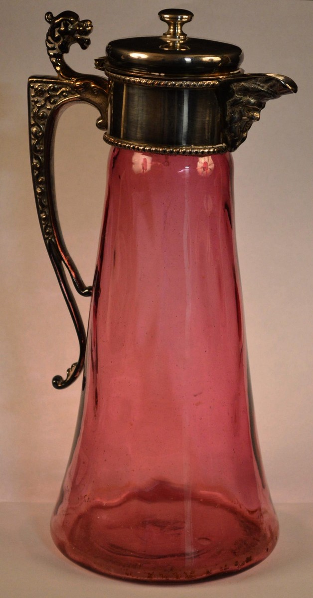 A RUBY GLASS CLARET JUG with plated mounts and handle.