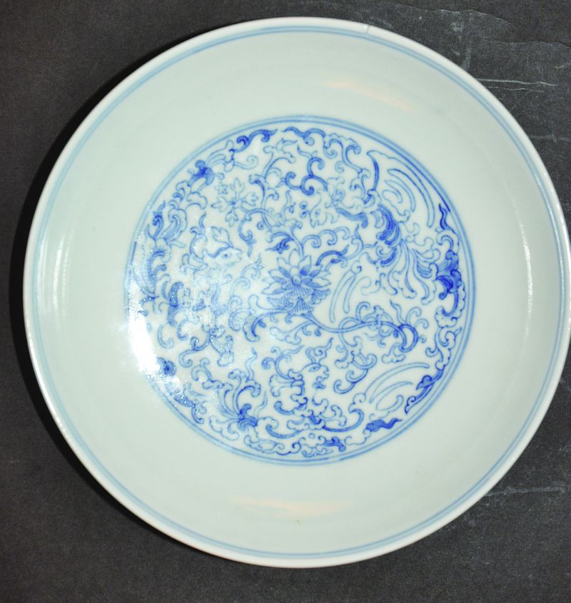 A CHINESE BLUE & WHITE PORCELAIN SAUCER DISH, painted with phoenix amidst scroll and leaf-stemmed