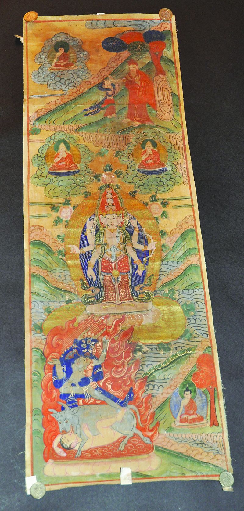 A TIBETAN THANGKA, painted on fabric with a multitude of deities and demons, 35.75in x 12in.