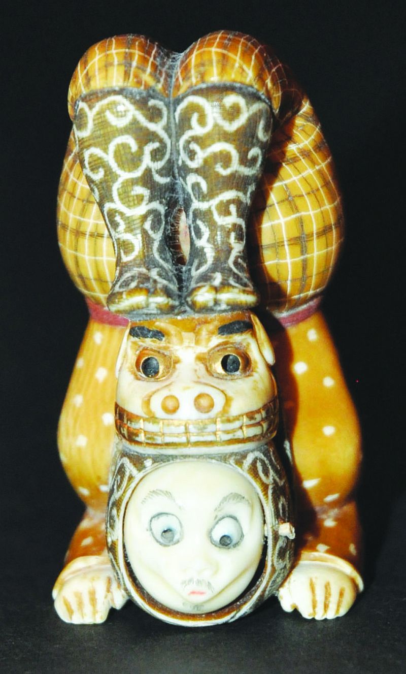 AN UNUSUAL 20TH CENTURY SIGNED JAPANESE IVORY NETSUKE OF A STREET PERFORMER, with shi-shi mask and