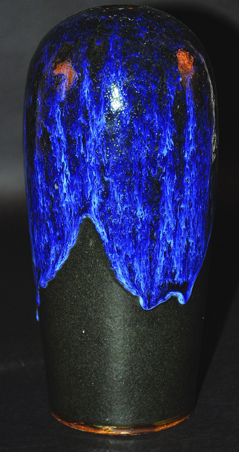 A CHINESE FLAMBÉ GLAZED PORCELAIN VASE, applied with a streaked purple glaze descending over a black