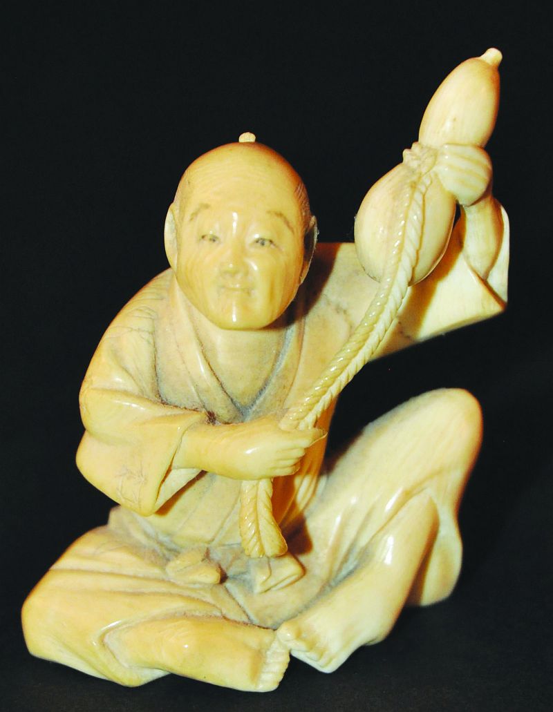 A JAPANESE IVORY OKIMONO OF A SEATED MAN, circa 1900, the man bearing aloft a rope-bound gourd, 2.