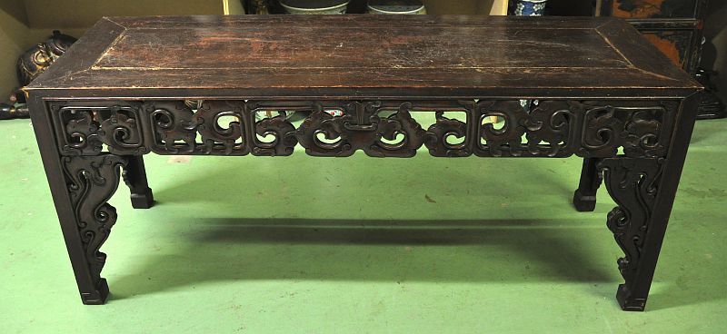 A 19TH CENTURY CHINESE PROVINCIAL CARVED HARDWOOD TABLE with carved undertier. 7ft 5ins x 1ft 2ins.
