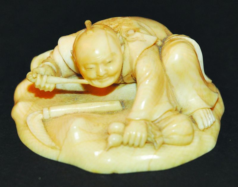 A GOOD QUALITY 19TH CENTURY JAPANESE IVORY NETSUKE, depicting a squatting farmer holding a pipe with