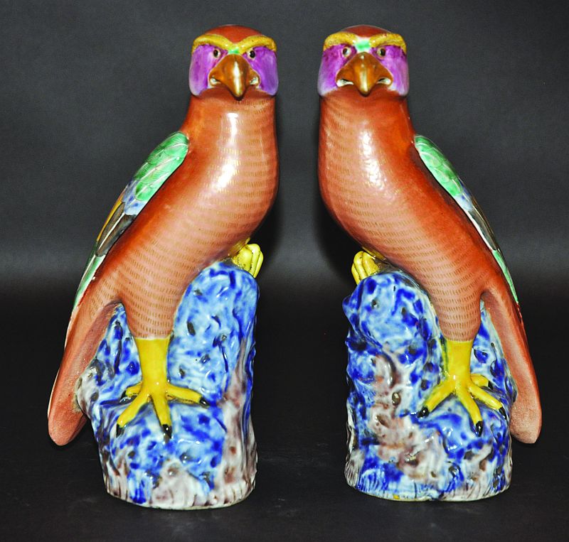 A MIRROR PAIR OF CHINESE ENAMELLED PORCELAIN HAWKS, each standing with inclined head on a rockwork