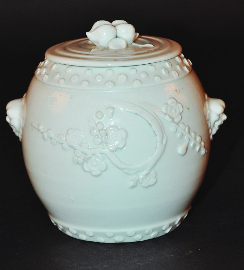 A 19TH CENTURY CHINESE BLANC-DE-CHINE BARREL & COVER, the rounded sides moulded with prunus