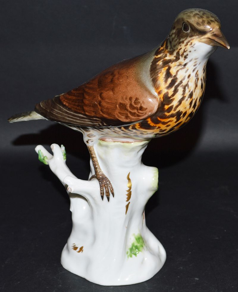 A MEISSEN MODEL OF A BIRD on a tree stump. Cross swords mark in blue. 8ins high.