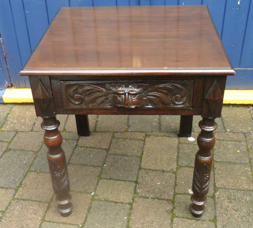 Square table with green man mask handle