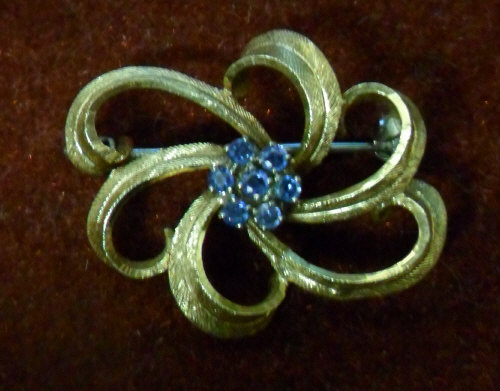 18ct gold open scroll brooch with 7 sapphire cluster centre