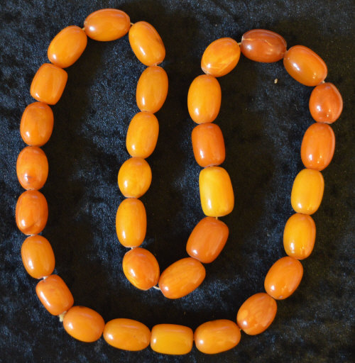 String of 32 amber beads mottle opaque & slightly irregular, approx 101g largest 2.2cm & total